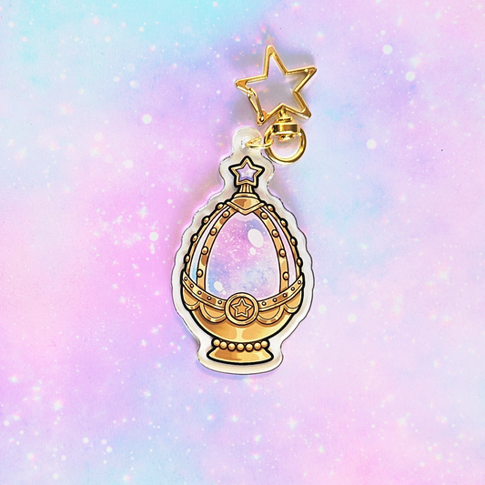 Gold charm with star on a pastel gradient background